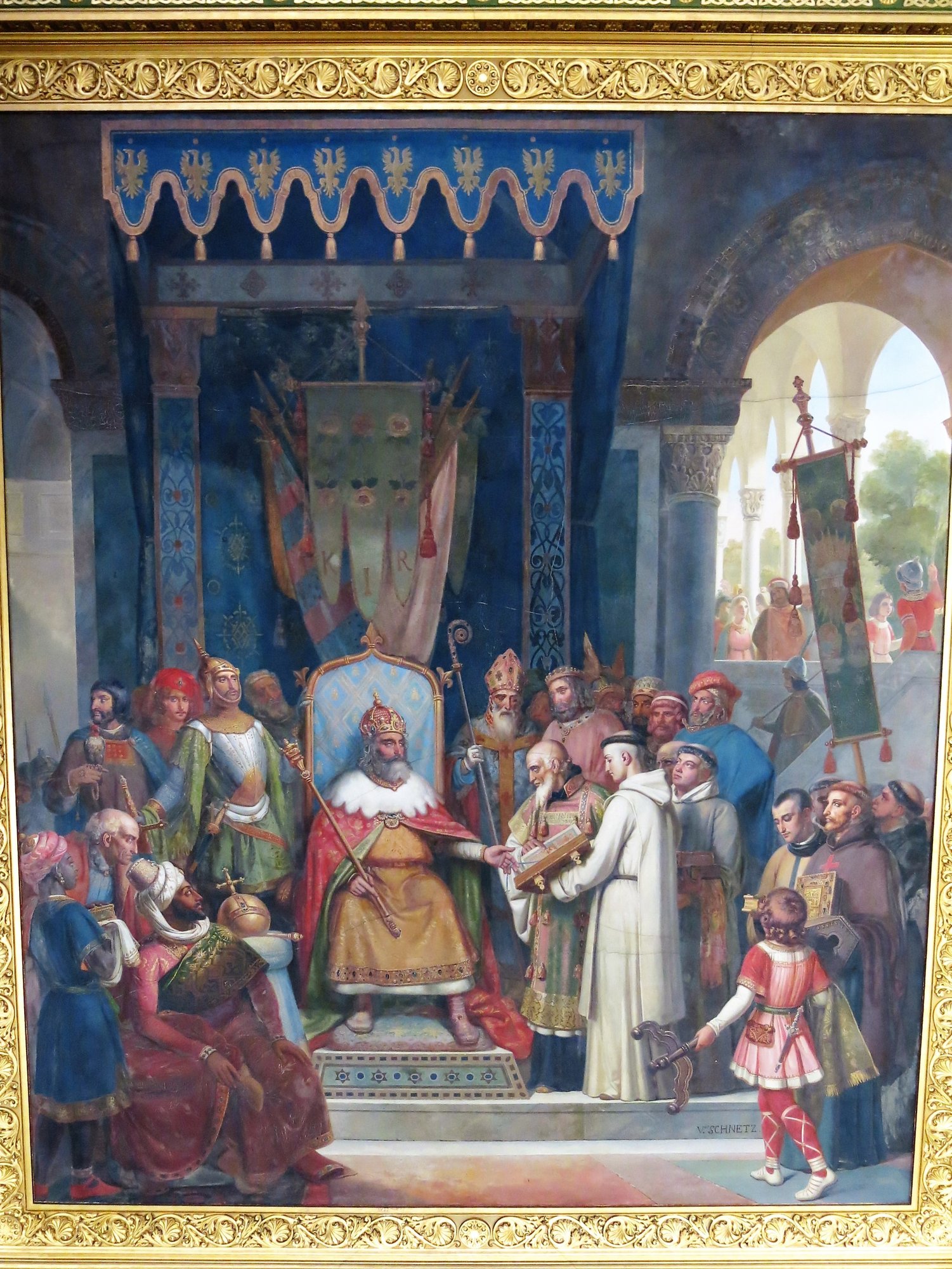 Illuminated manuscript scene in a gilt border showing a crowned ruler enthroned among robed courtiers and clergy under a canopy